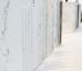 Various types of white marble slabs displayed in stone showroom including Carrara, Calacatta, and other white marble varieties with different veining patterns for selection