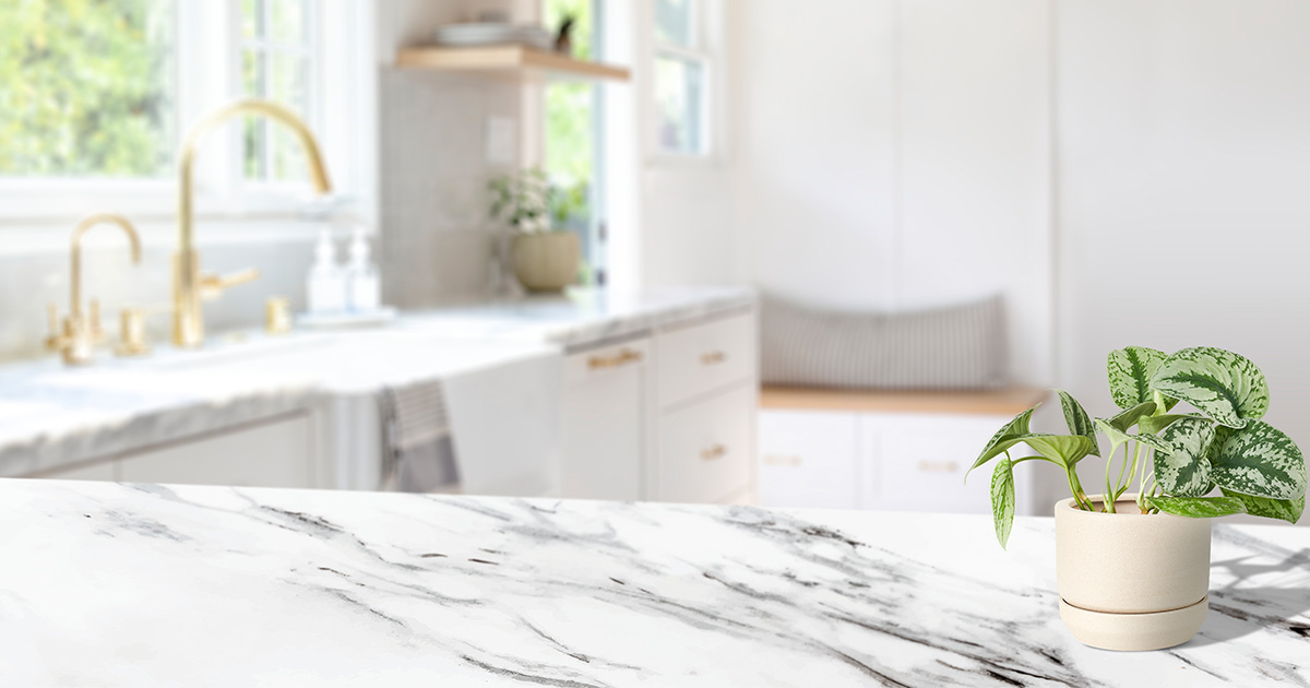 White marble countertop with bold gray veining in a bright kitchen, showing the natural beauty and aesthetic appeal of marble as a countertop material.